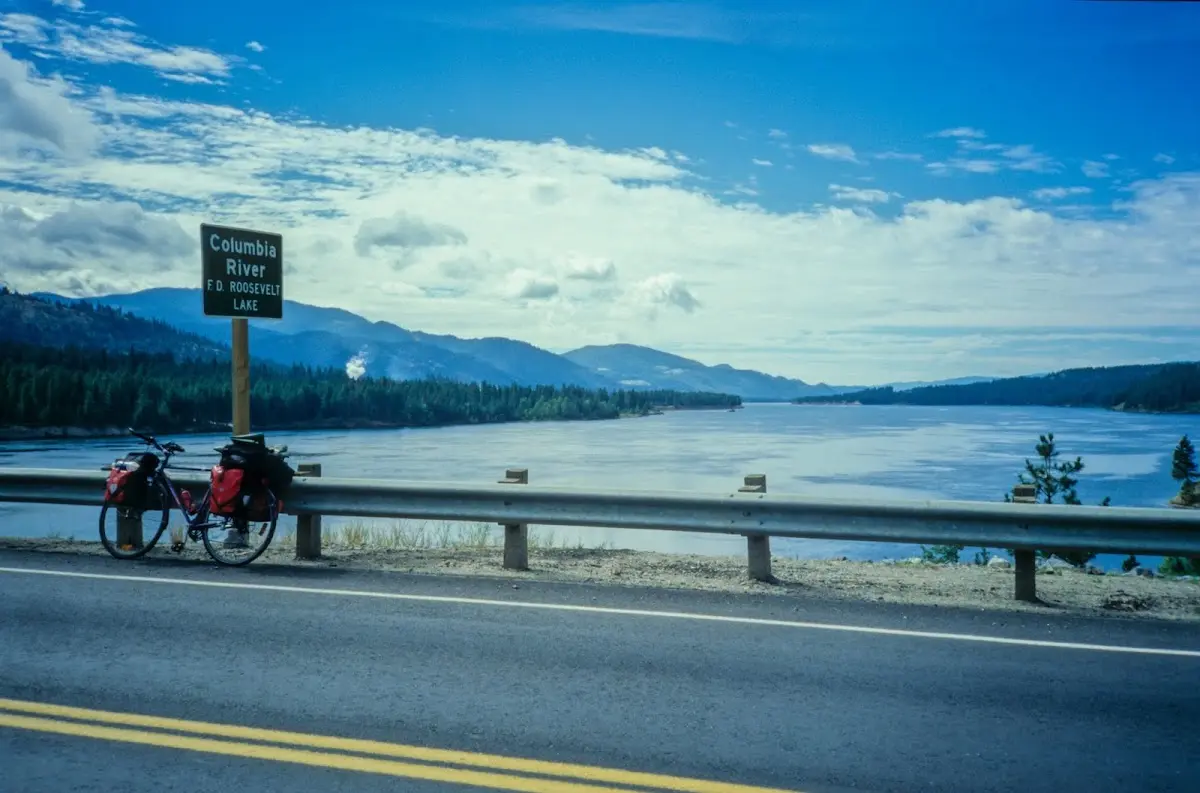 Reiserad an der Leitplanke mit Blick über den Columbia River auf die Berge