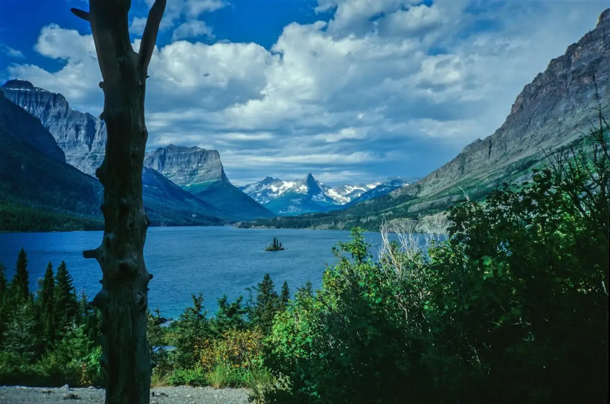 Bergsee mit einer kleinen Insel zwischen steilen Felswänden unter Wolken