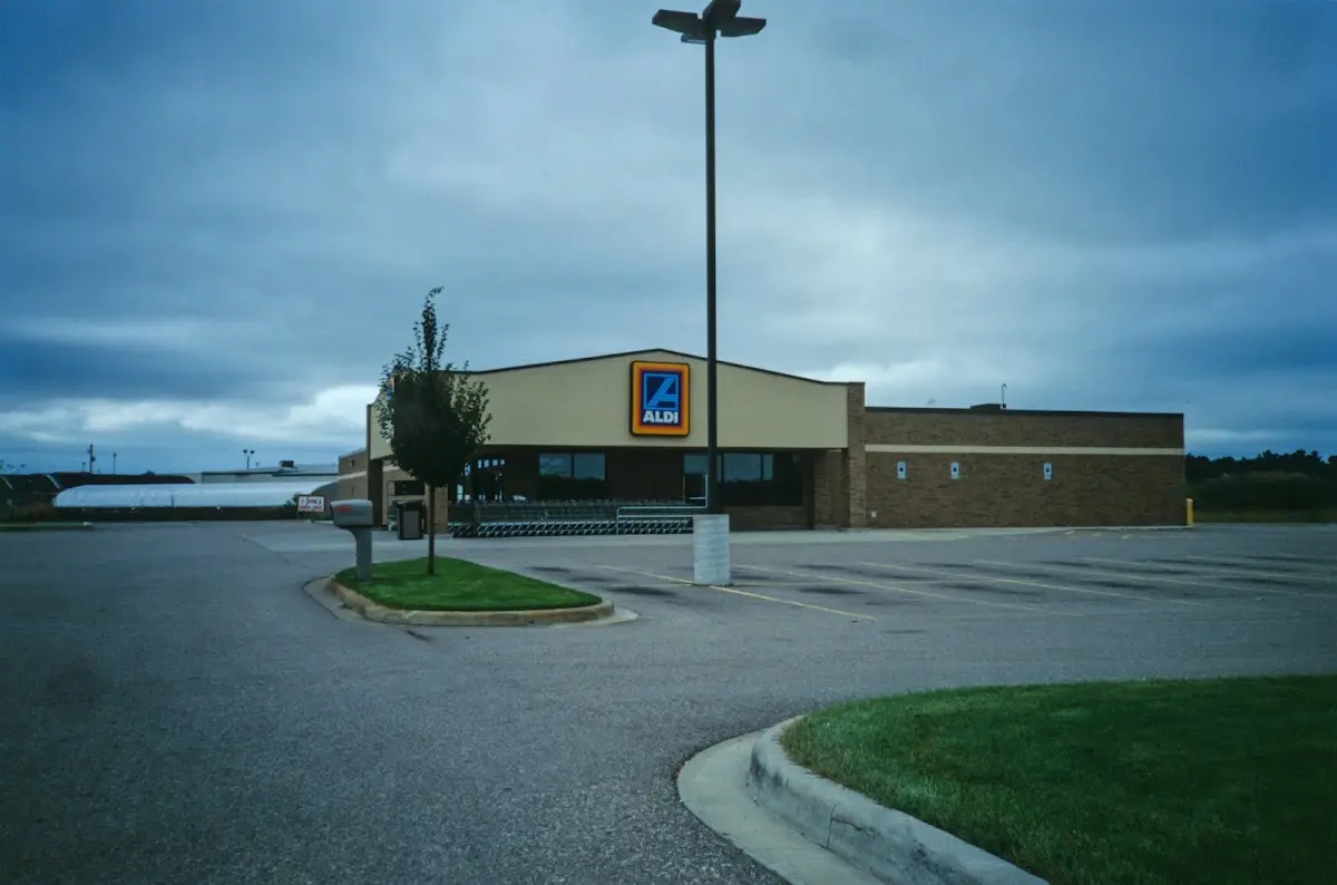 Aldi-Markt mit leerem Parkplatz unter dunklen Wolken